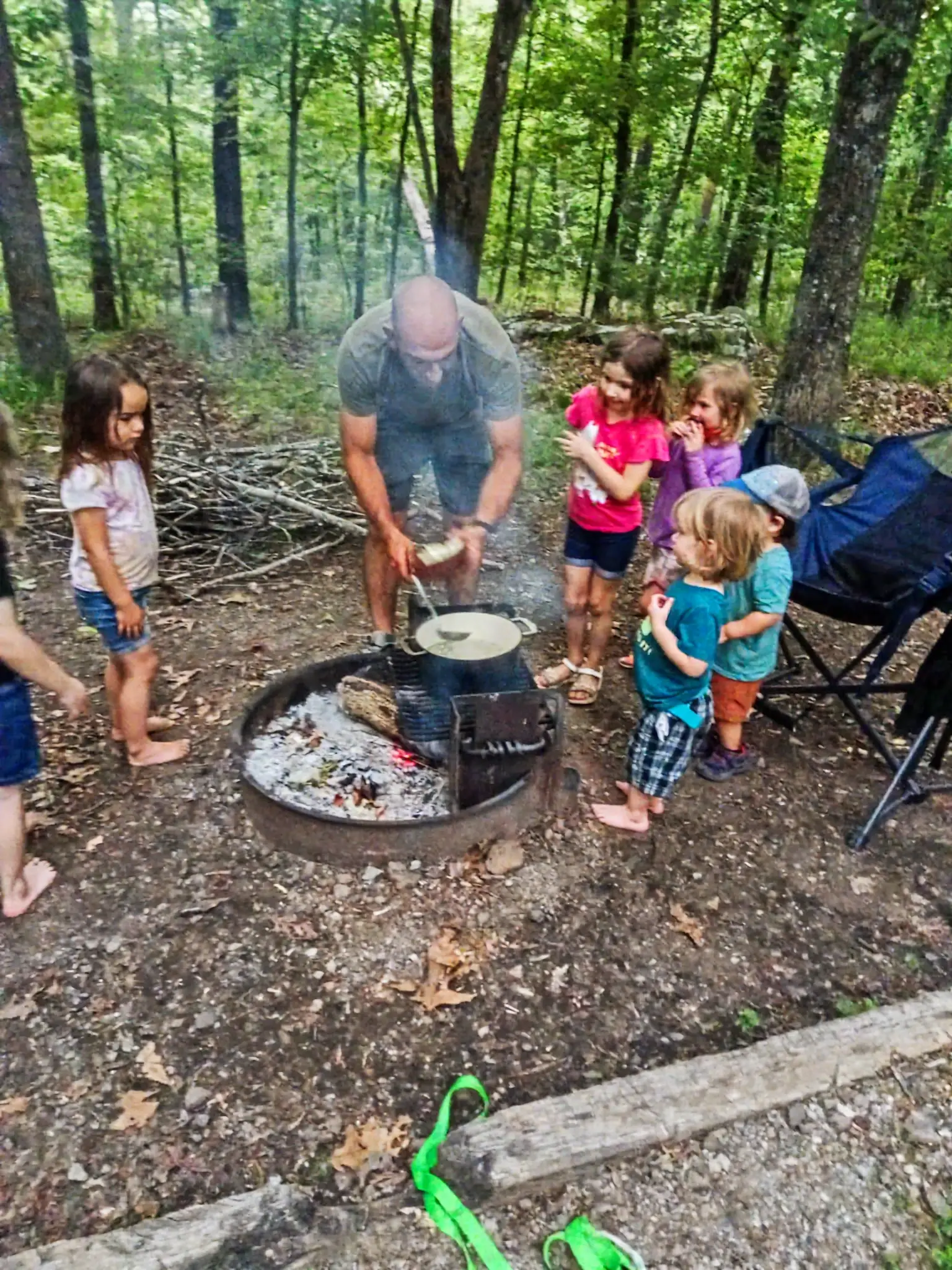 Jon Poyner cooking with kids over a campfire at Tulsa Forest School