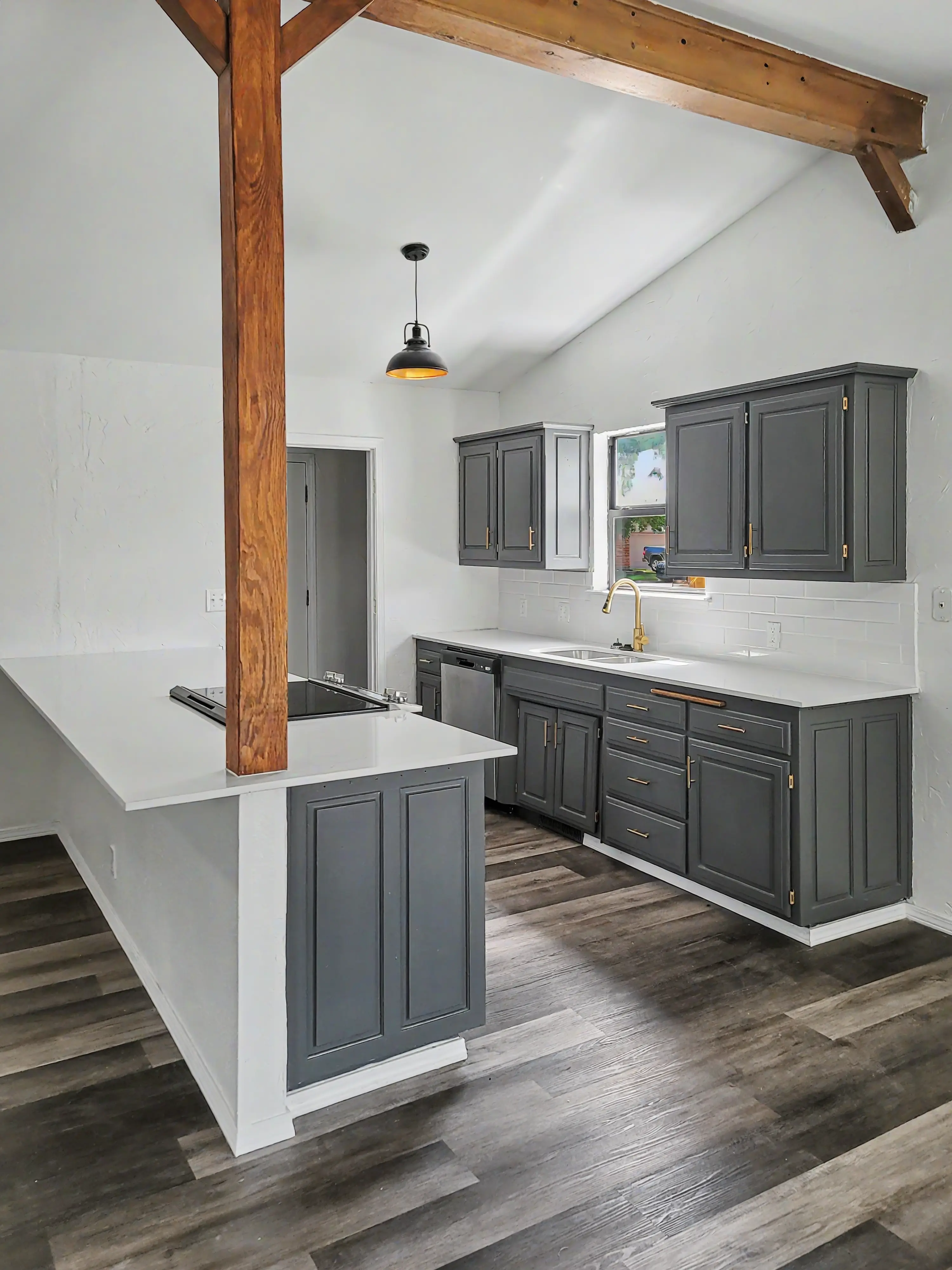 Kitchen remodel in Tulsa Oklahoma with gray cabinets, wood beam detail, and upgraded finishes