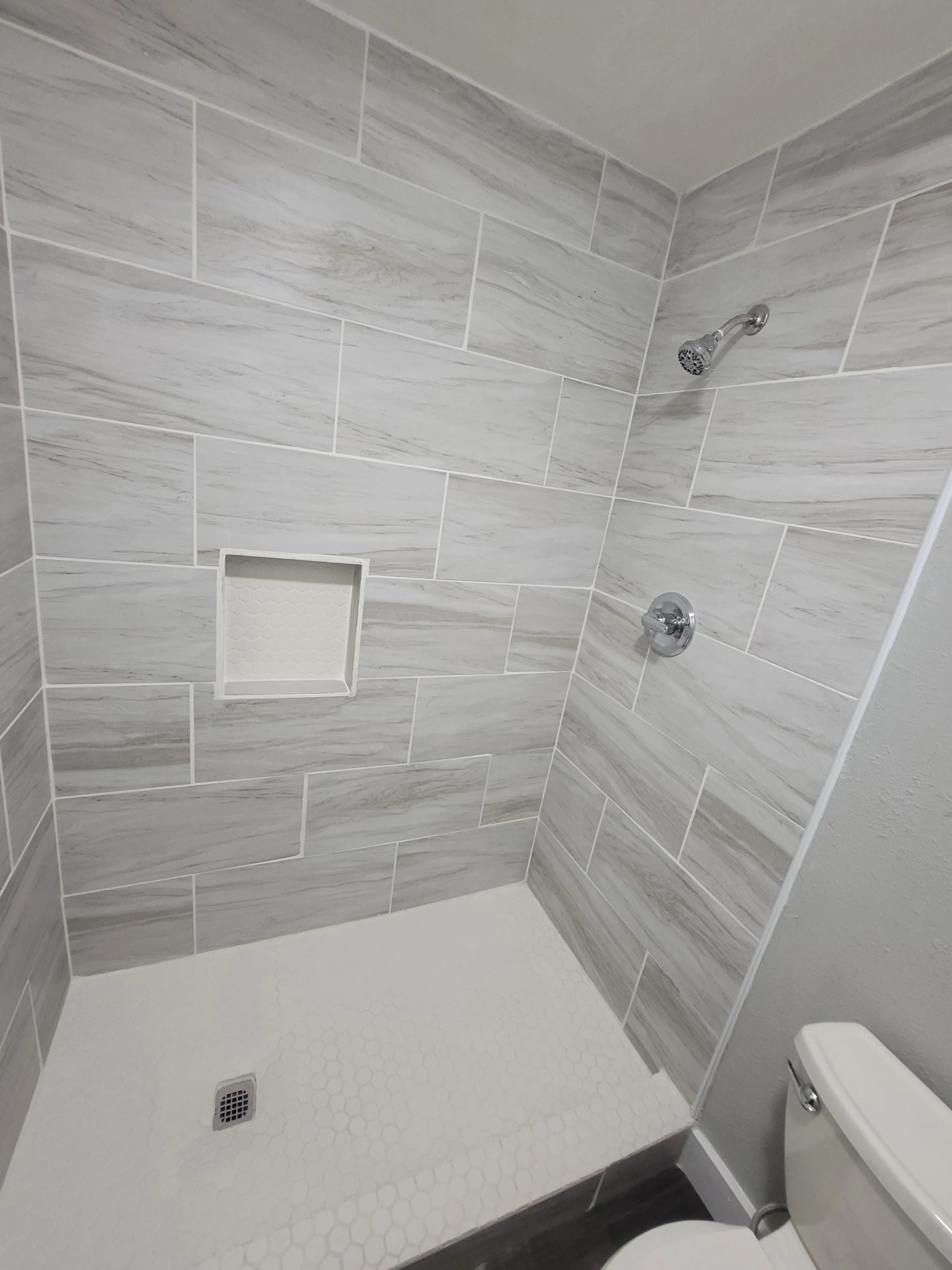 After master bath shower expansion with updated tile and improved layout in Tulsa