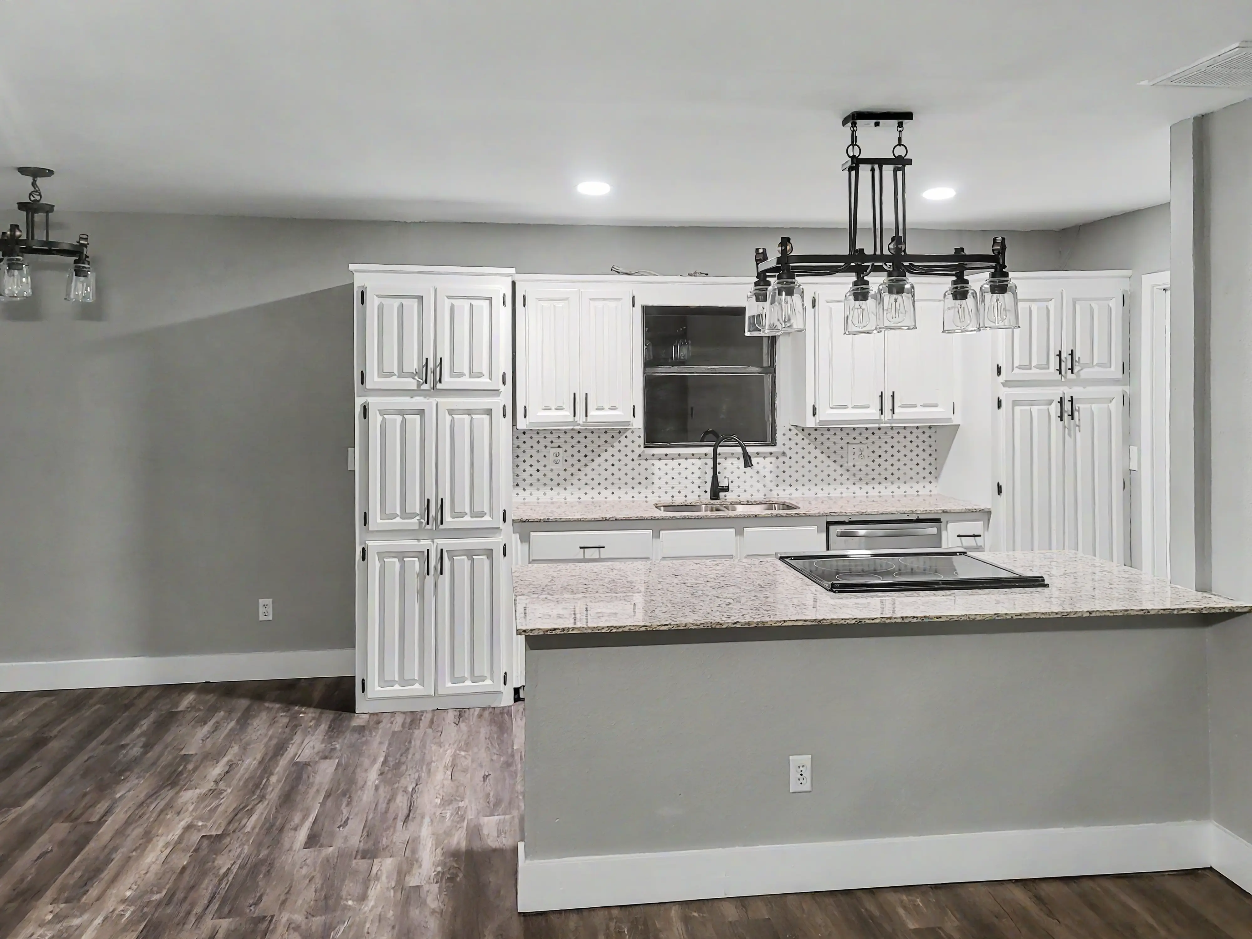 After remodel kitchen with white cabinetry and island in Tulsa home